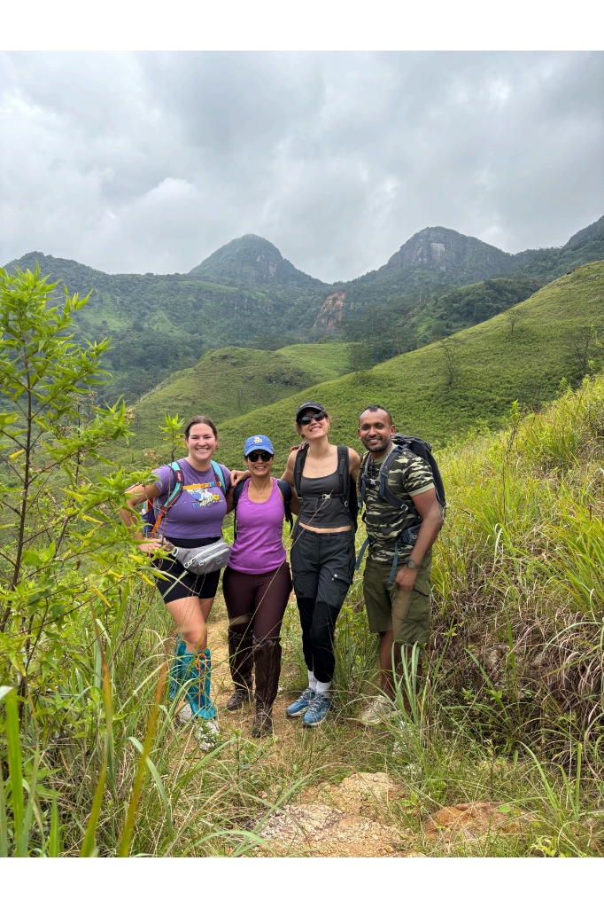 Hikers and guide Ravi on a scenic mountain ridge trail overlooking the Knuckles Mountain Range peaks