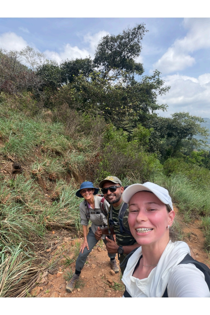 Smiling hikers and guide Ravi taking a selfie on an uphill mountain trail in the Knuckles Range